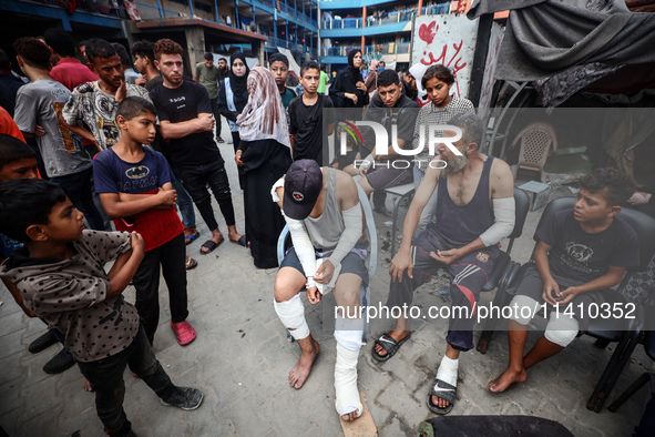 Wounded Palestinians are sitting inside a school run by the UN Relief and Works Agency for Palestine Refugees (UNRWA) that was previously hi...