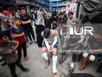 Wounded Palestinians are sitting inside a school run by the UN Relief and Works Agency for Palestine Refugees (UNRWA) that was previously hi...