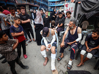 Wounded Palestinians are sitting inside a school run by the UN Relief and Works Agency for Palestine Refugees (UNRWA) that was previously hi...