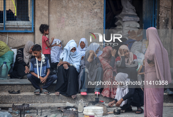 Palestinians are sitting inside a school run by the UN Relief and Works Agency for Palestine Refugees (UNRWA) that was previously hit by Isr...