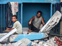 Palestinians are sitting inside a school run by the UN Relief and Works Agency for Palestine Refugees (UNRWA) that was previously hit by Isr...