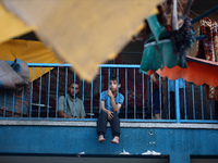 A Palestinian boy is watching as people are checking the destruction at a school run by the UN Relief and Works Agency for Palestine Refugee...