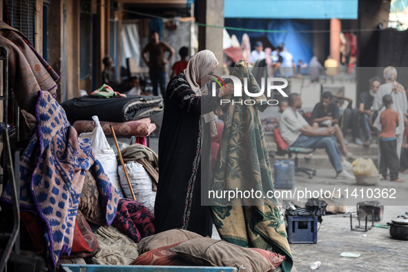 People are checking the destruction at a school run by the UN Relief and Works Agency for Palestine Refugees (UNRWA) that was previously hit...