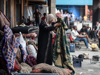 People are checking the destruction at a school run by the UN Relief and Works Agency for Palestine Refugees (UNRWA) that was previously hit...