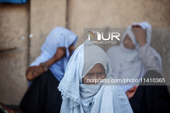 Palestinians are sitting inside a school run by the UN Relief and Works Agency for Palestine Refugees (UNRWA) that was previously hit by Isr...