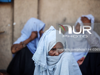 Palestinians are sitting inside a school run by the UN Relief and Works Agency for Palestine Refugees (UNRWA) that was previously hit by Isr...