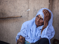 An injured woman is sitting at a school run by the UN Relief and Works Agency for Palestine Refugees (UNRWA) that was previously hit by Isra...