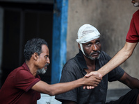 An injured man is sitting at a school run by the UN Relief and Works Agency for Palestine Refugees (UNRWA) that was previously hit by Israel...