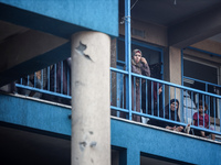 A Palestinian woman is watching as people are checking the destruction at a school run by the UN Relief and Works Agency for Palestine Refug...