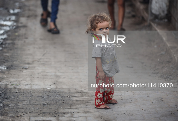 A Palestinian girl is watching as people are checking the destruction at a school run by the UN Relief and Works Agency for Palestine Refuge...