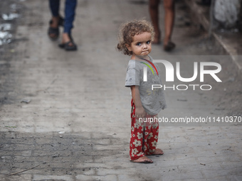 A Palestinian girl is watching as people are checking the destruction at a school run by the UN Relief and Works Agency for Palestine Refuge...