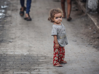 A Palestinian girl is watching as people are checking the destruction at a school run by the UN Relief and Works Agency for Palestine Refuge...