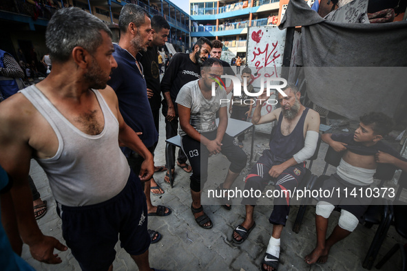 Wounded Palestinians are sitting inside a school run by the UN Relief and Works Agency for Palestine Refugees (UNRWA) that was previously hi...