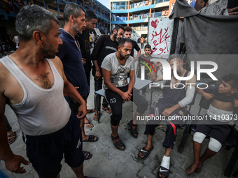 Wounded Palestinians are sitting inside a school run by the UN Relief and Works Agency for Palestine Refugees (UNRWA) that was previously hi...