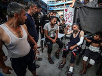 Wounded Palestinians are sitting inside a school run by the UN Relief and Works Agency for Palestine Refugees (UNRWA) that was previously hi...