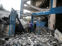 People are checking the destruction at a school run by the UN Relief and Works Agency for Palestine Refugees (UNRWA) that was previously hit...