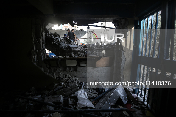 People are checking the destruction at a school run by the UN Relief and Works Agency for Palestine Refugees (UNRWA) that was previously hit...