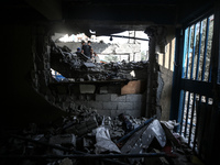 People are checking the destruction at a school run by the UN Relief and Works Agency for Palestine Refugees (UNRWA) that was previously hit...