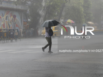 A man is crossing a road during heavy monsoon rain in Kolkata, India, on July 15, 2024. (