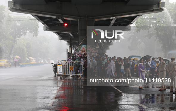 People are taking shelter under a flyover during heavy monsoon rain in Kolkata, India, on July 15, 2024. 