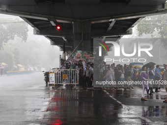 People are taking shelter under a flyover during heavy monsoon rain in Kolkata, India, on July 15, 2024. (