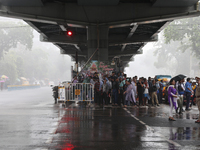 People are taking shelter under a flyover during heavy monsoon rain in Kolkata, India, on July 15, 2024. (