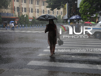 A woman is crossing a road during heavy monsoon rain in Kolkata, India, on July 15, 2024. (