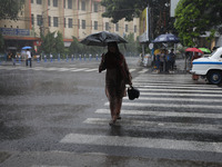 A woman is crossing a road during heavy monsoon rain in Kolkata, India, on July 15, 2024. (