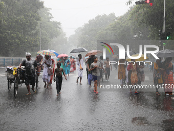 Commuters are walking on a road with umbrellas during heavy monsoon rain in Kolkata, India, on July 15, 2024. (