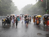 Commuters are walking on a road with umbrellas during heavy monsoon rain in Kolkata, India, on July 15, 2024. (