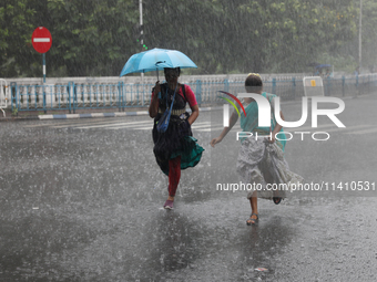 Women are crossing a road during heavy monsoon rain in Kolkata, India, on July 15, 2024. (