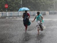 Women are crossing a road during heavy monsoon rain in Kolkata, India, on July 15, 2024. (