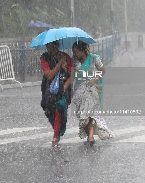 Women are crossing a road during heavy monsoon rain in Kolkata, India, on July 15, 2024. 