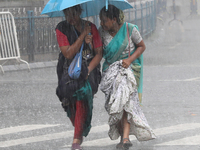 Women are crossing a road during heavy monsoon rain in Kolkata, India, on July 15, 2024. (