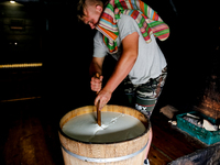 Piotr, son of Baca Krzysztof Las (a traditional Polish Carpathian mountains shepherd) prepares sheep milk to make cheese in Traditional wood...