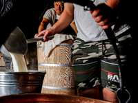 Baca Krzysztof Las (a traditional Polish Carpathian mountains shepherd) and his son prepares sheep milk to make cheese in Traditional wooden...