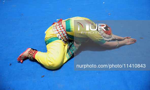 An artist is offering prayer after performing on the last day of the week-long celebration of Rath Yatra, or chariot procession, in Kolkata,...