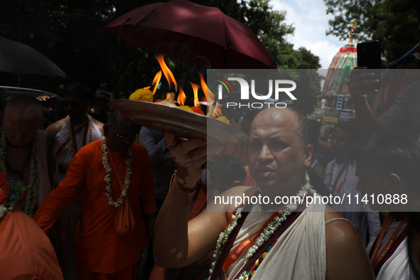 A Hindu priest is worshipping the idol of Lord Jagannath on the last day of the week-long celebration of Rath Yatra, or chariot procession,...