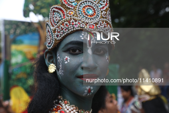 An artist is dressing as Hindu Lord Krishna as he is waiting to perform on the last day of the week-long celebration of Lord Jagannath's ''R...