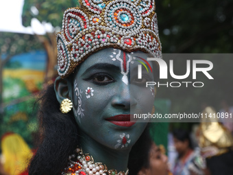 An artist is dressing as Hindu Lord Krishna as he is waiting to perform on the last day of the week-long celebration of Lord Jagannath's ''R...