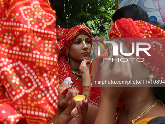 An artist is getting her make-up done before she performs on the last day of the week-long celebration of Rath Yatra, or chariot procession,...