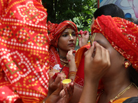 An artist is getting her make-up done before she performs on the last day of the week-long celebration of Rath Yatra, or chariot procession,...