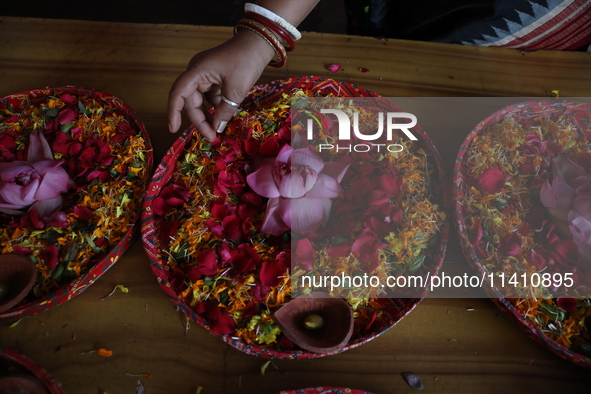 A Hindu devotee is preparing trays of offerings before she participates on the last day of the week-long celebration of Rath Yatra, or chari...