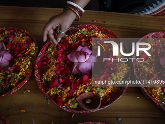 A Hindu devotee is preparing trays of offerings before she participates on the last day of the week-long celebration of Rath Yatra, or chari...