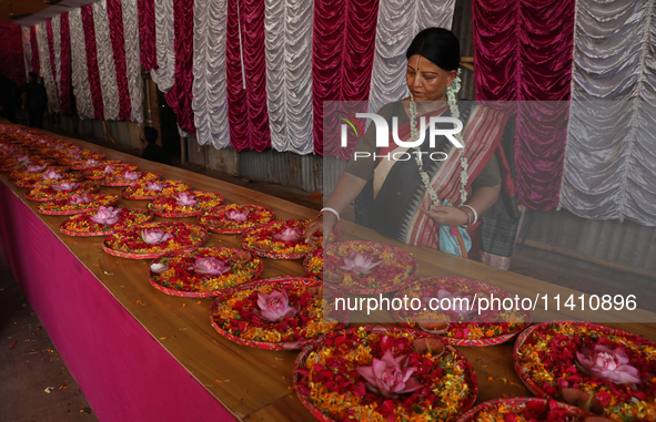 A Hindu devotee is preparing trays of offerings before she participates on the last day of the week-long celebration of Rath Yatra, or chari...