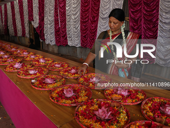 A Hindu devotee is preparing trays of offerings before she participates on the last day of the week-long celebration of Rath Yatra, or chari...