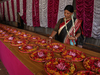 A Hindu devotee is preparing trays of offerings before she participates on the last day of the week-long celebration of Rath Yatra, or chari...