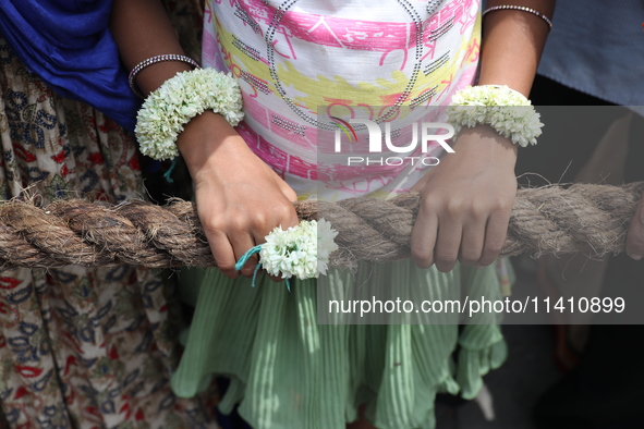 A Hindu girl is holding a rope to pull a ''Rath'', or the chariot of Lord Jagannath, to seek blessings on the last day of the week-long cele...