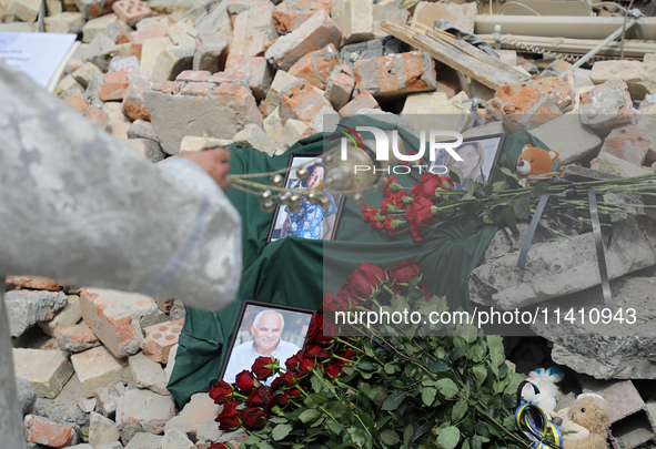 A priest is swinging the censer at the photographs of health professionals killed by the Russian missile attack on the Ohmatdyt National Spe...