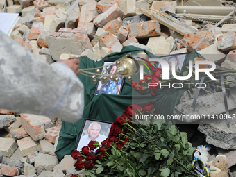 A priest is swinging the censer at the photographs of health professionals killed by the Russian missile attack on the Ohmatdyt National Spe...